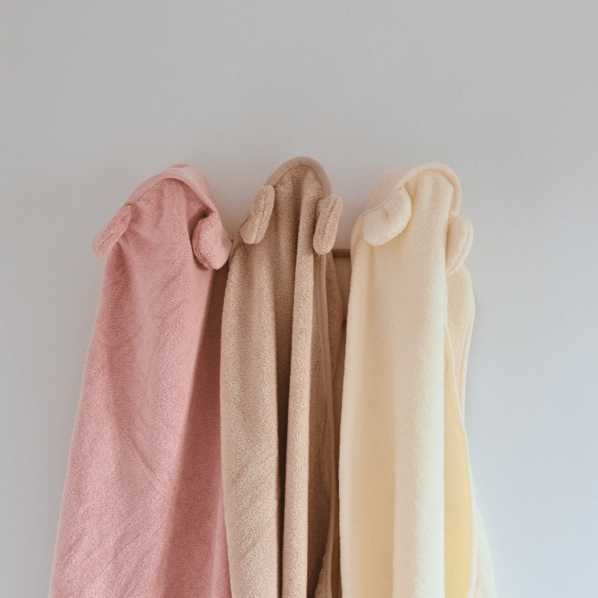 capes de bain personnalisé avec différents prénoms accroché au mur