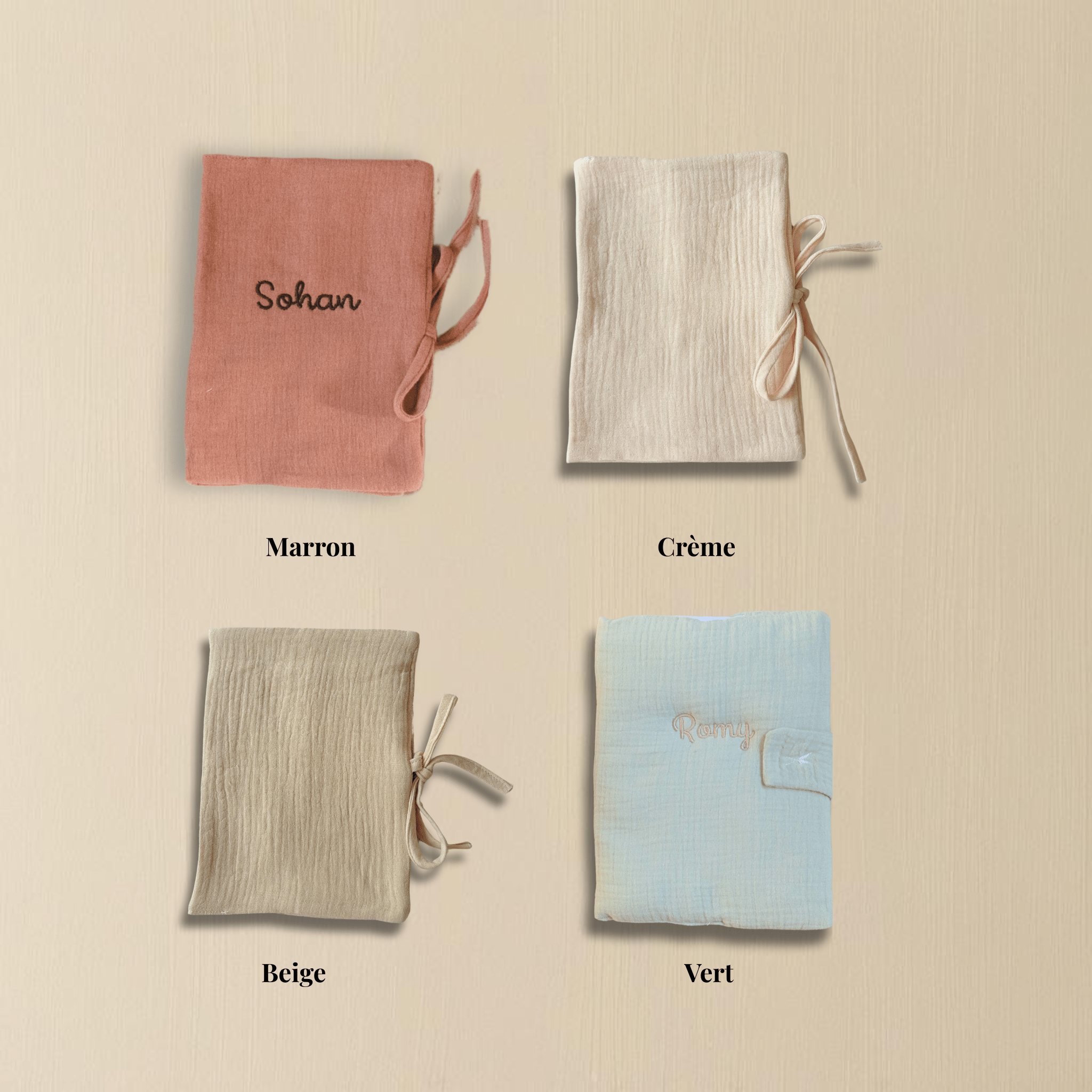 Quatre protège-carnets de santé en coton gaufré personnalisés, présentés en coloris marron, crème, beige et vert, brodés aux prénoms Sohan et Romy, posés sur fond bois clair.