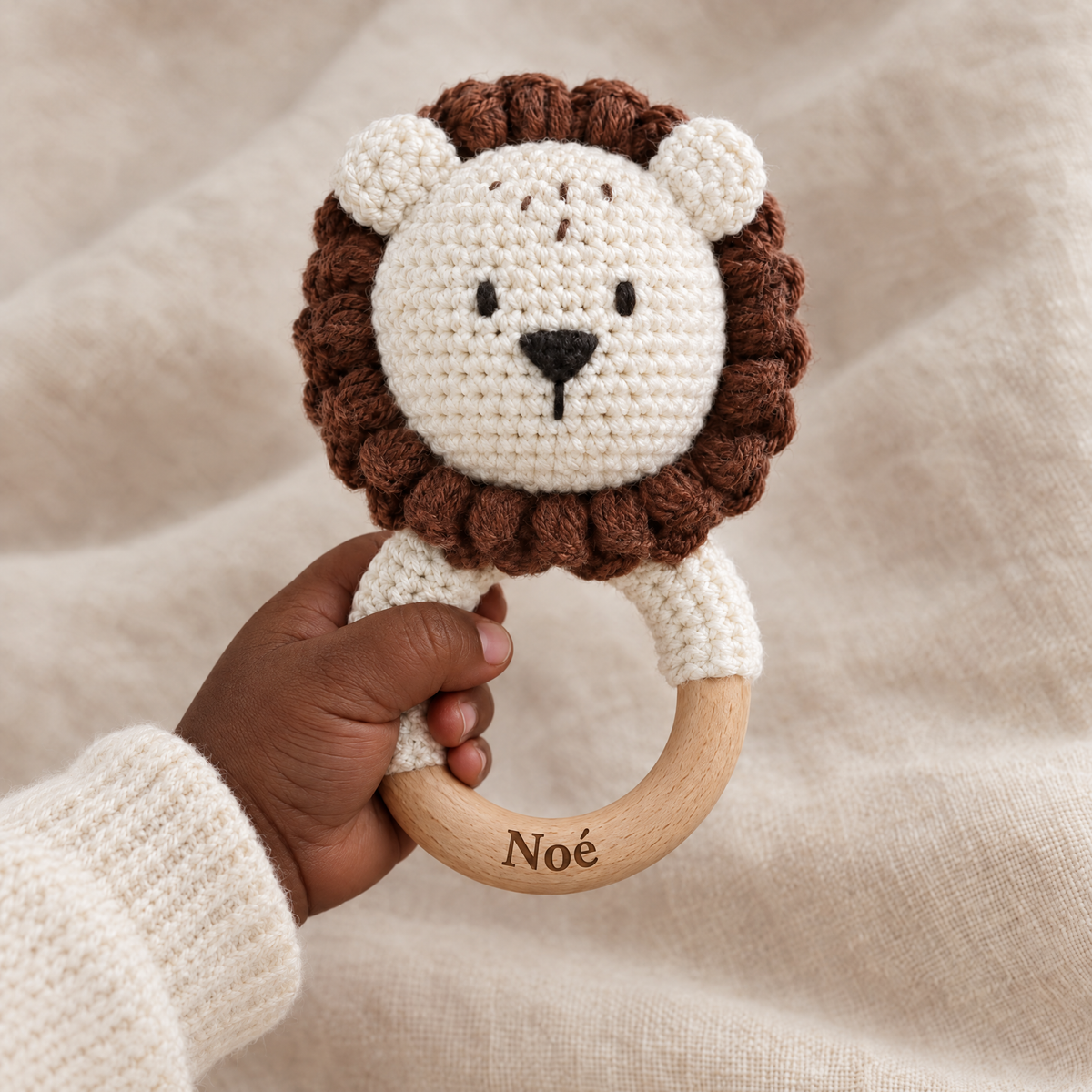 Hochet en crochet personnalisé lion brun tenu par bébé, prénom gravé