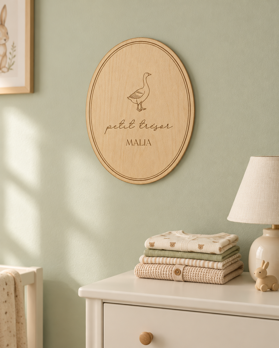 Plaque ovale gravée accrochée au mur d'une chambre de bébé