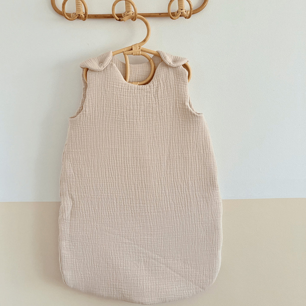 Gigoteuse Cocon beige en gaze de coton, accrochée au mur