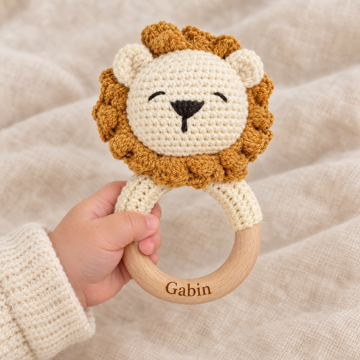 Hochet en crochet personnalisé lion roux tenu par bébé, prénom gravé