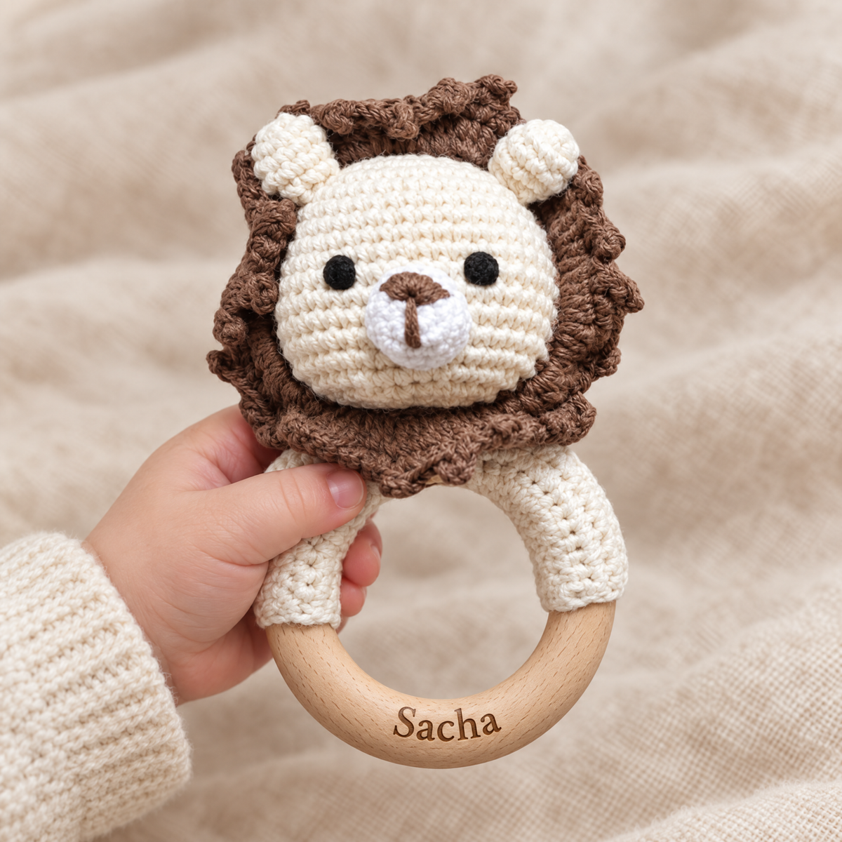 Hochet en crochet personnalisé lion brun tenu par bébé, prénom gravé