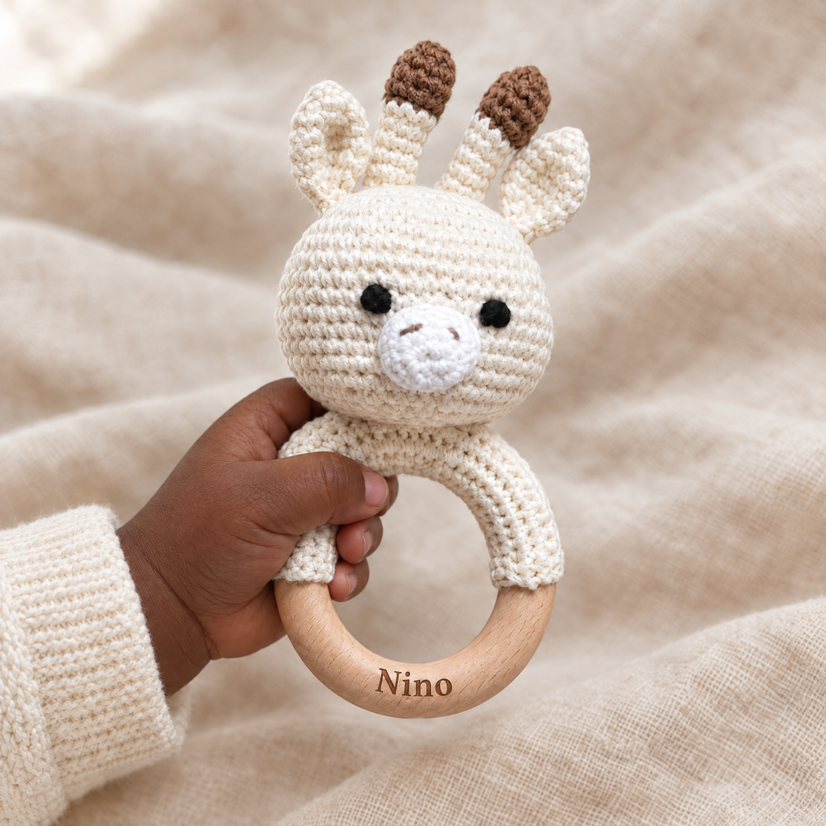 Hochet en crochet personnalisé girafe tenu par bébé, prénom gravé